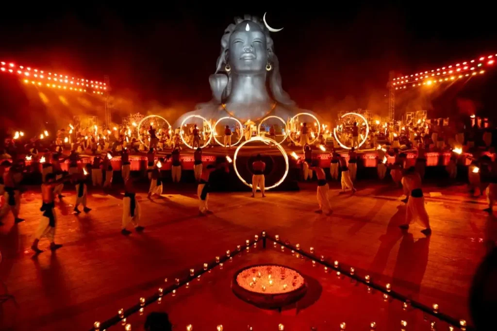Performers spinning fire hoops in front of the massive Adiyogi Shiva statue during the Maha Shivratri celebrations.
